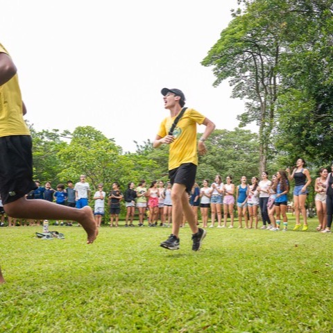 Monitores puxando músicas na roda de cantoria, com as crianças em volta