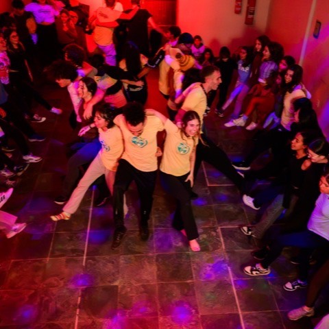Crianças dançando sob luzes coloridas na discoteca