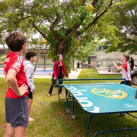 Crianças jogando tênis de mesa no horário livre
